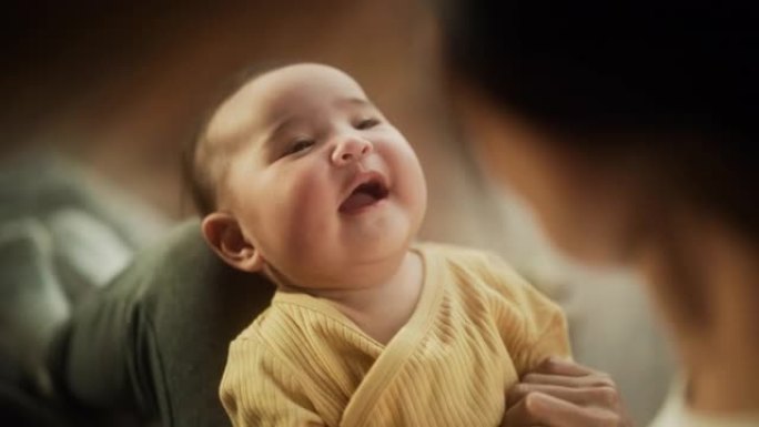 一个可爱的亚洲婴儿的肖像笑着，躺在母亲的腿上，一起享受着一段亲密的时光，带着爱看着她。顽皮的妈妈玩躲