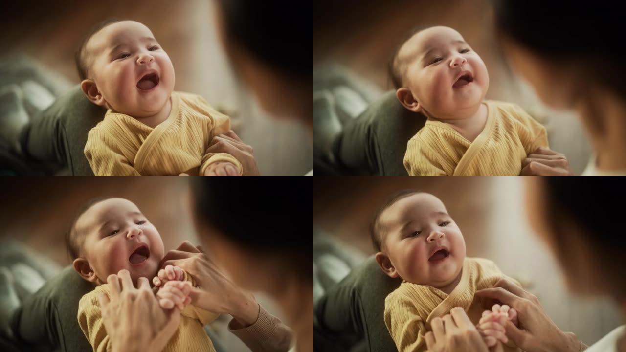 一个可爱的亚洲婴儿的肖像笑着，躺在母亲的腿上，一起享受着一段亲密的时光，带着爱看着她。顽皮的妈妈玩躲