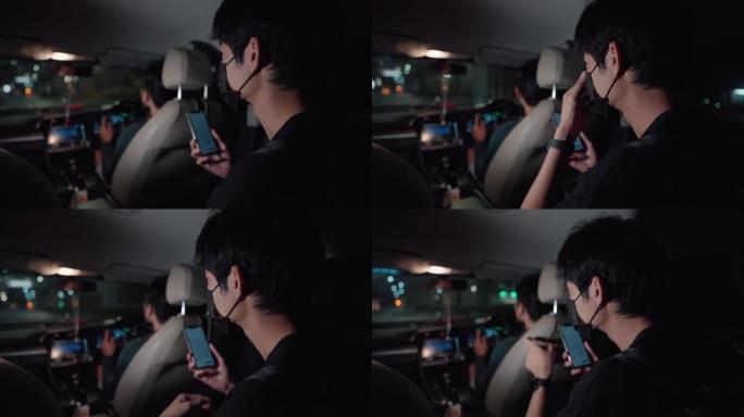 坐在出租车司机后面的亚洲乘客使用他的智能手机向司机解释一个位置。
