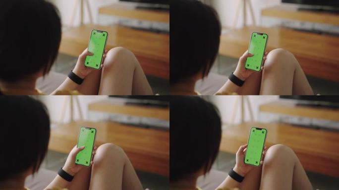 女人在家里使用和看智能手机绿屏