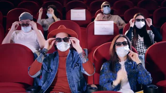 电影，电影，娱乐概念。戴着口罩的人在电影院戴眼镜