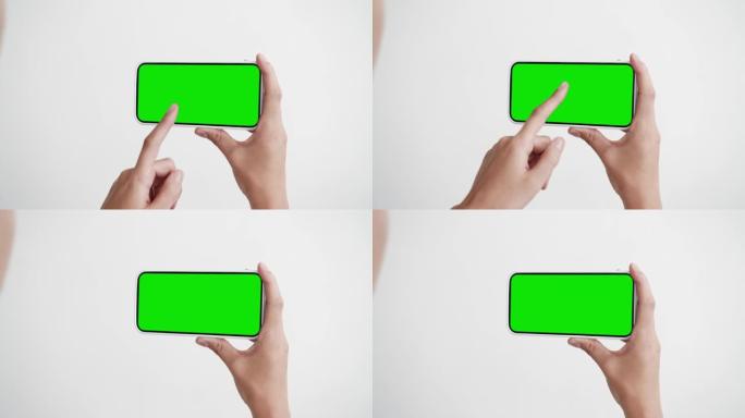 年轻人看屏幕智能手机与绿色色度键特写。女孩手里拿着点击手机模型POV。概念观看节目电影，互联网社交媒