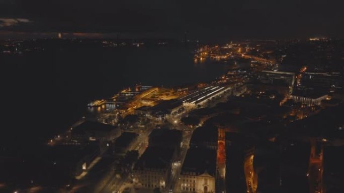 葡萄牙里斯本夜市无人机景观。河岸上的照明建筑。桥梁的光轮廓