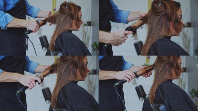 发型师在美容院用铁棒卷曲女性客户的头发