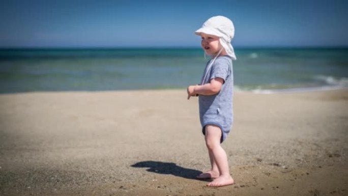 站在沙滩上的蹒跚学步的男孩