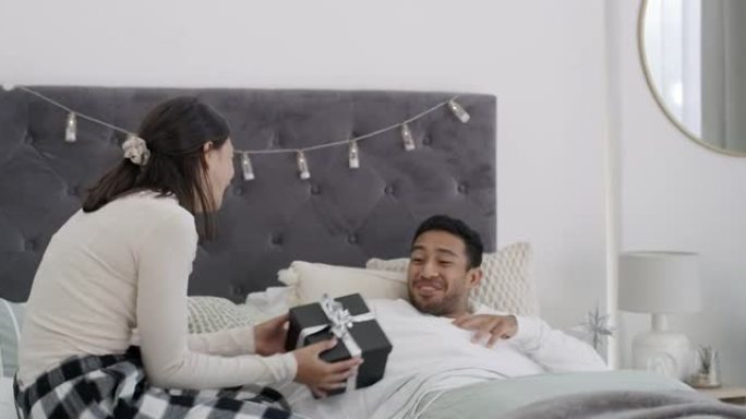 一对年轻夫妇在家床上交换礼物的4k视频片段