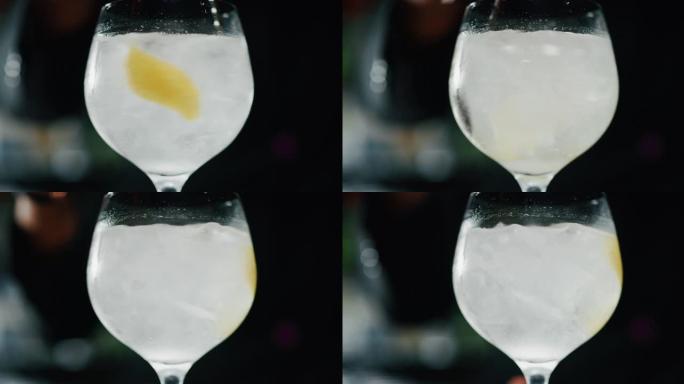 专业调酒师的特写镜头是在酒吧或迪斯科俱乐部向顾客混合杜松子酒补品和专业水晶冰块。