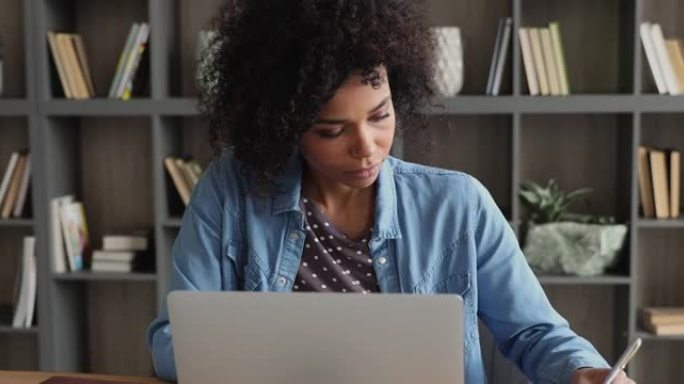 体贴的千禧一代非洲女性在电脑上学习。