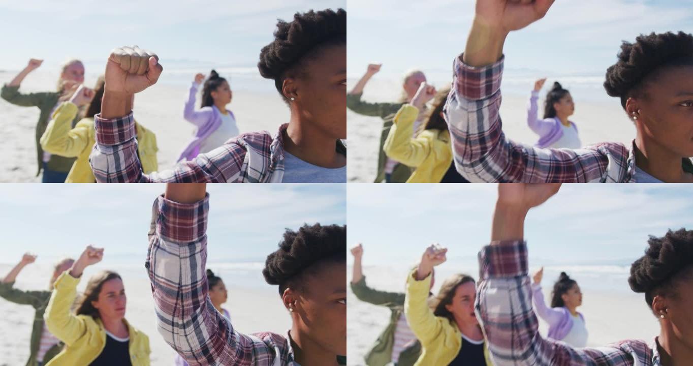 多元化的女性朋友在海滩上举起拳头