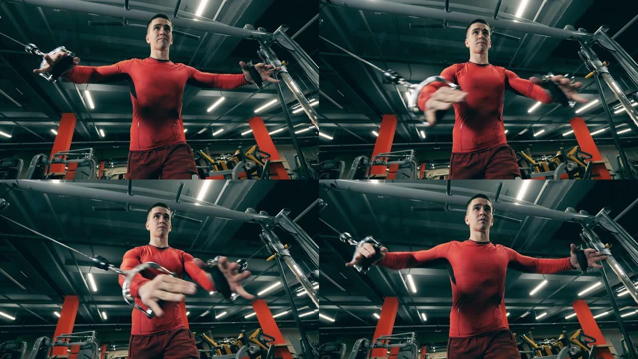 一名男子在锻炼过程中使用健身机进行手臂锻炼