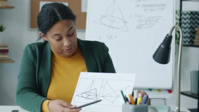 非裔美国女士的肖像在线教学几何在家庭办公室里说话和看相机