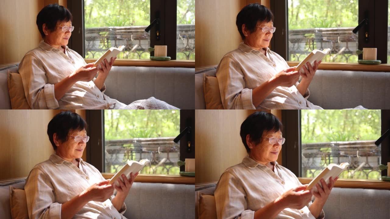 老年女性在家看书女人坐在沙发上靠窗笔记本