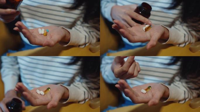 生病的亚洲年轻女士拿着药丸看一眼药坐在家里的沙发上晚上。女孩在医生命令后服药，在家检疫。