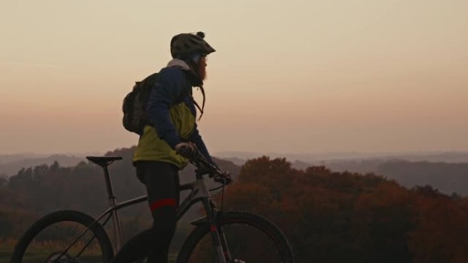 SLO MO Mountain骑自行车的人在黄昏时在乡下骑自行车时停下来休息一下