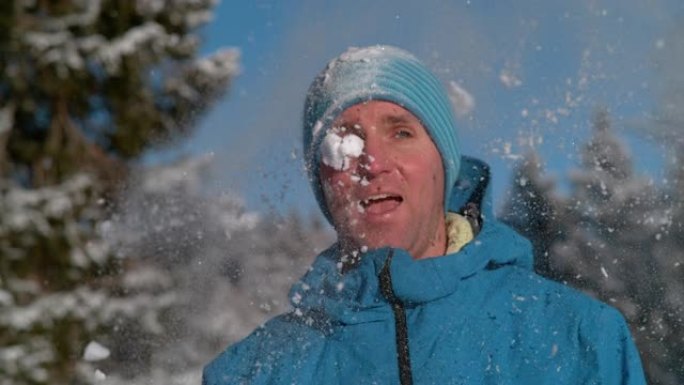 肖像，dop: 斜视的男性游客被蓬松的雪球击中。