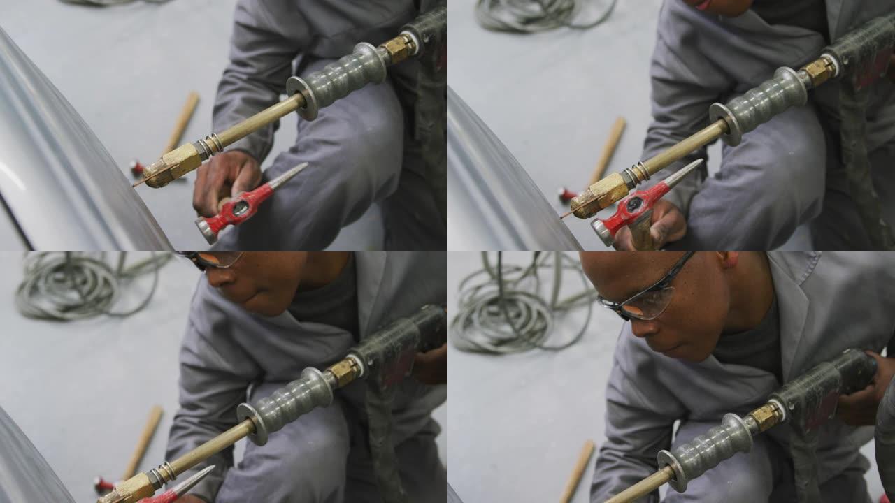 非裔美国男汽车修理工手持螺丝刀用锤子修车