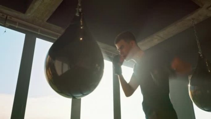 在健身房踢拳击，袋和男子出气筒，以增强力量，健身和锻炼身体。健康中心适合武术、拳击和体育锻炼的强壮、