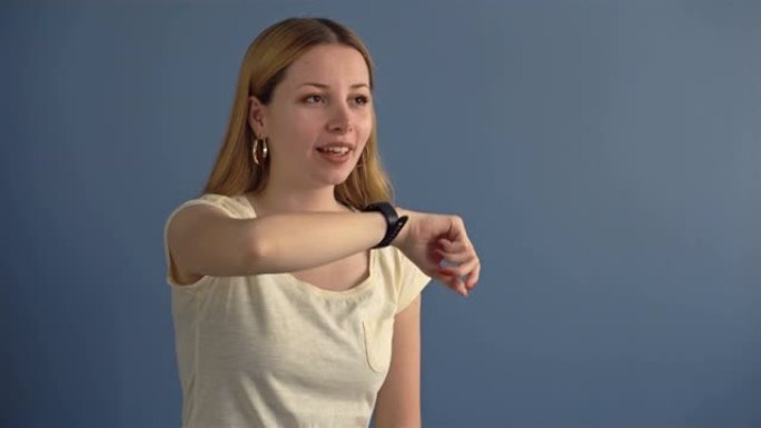办公室里的女人通过智能手表发送音频信息。从事智能手表的年轻女性专业人士