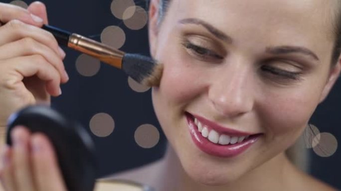 4k视频片段，一位迷人的年轻女子在工作室背景下用刷子化妆