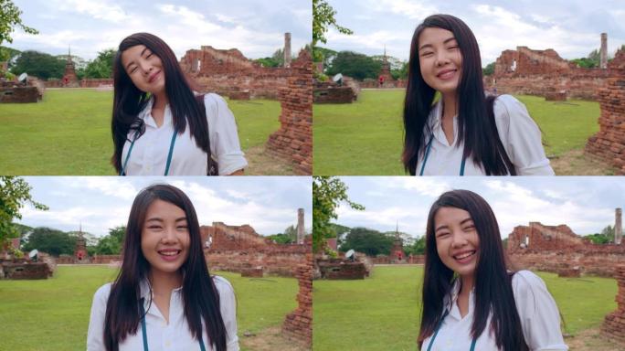 开朗美丽的年轻亚洲背包客博客写手女人随手拍照，微笑着在老城区的宝塔旅行。