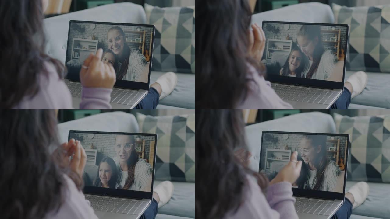 年轻妇女和儿童在家里使用笔记本电脑进行在线视频通话聊天和大笑