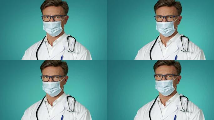 穿着医用口罩的英俊男医生在室内慢动作的肖像。人和传染病。医务人员白色实验室外套和眼镜。医学概念。