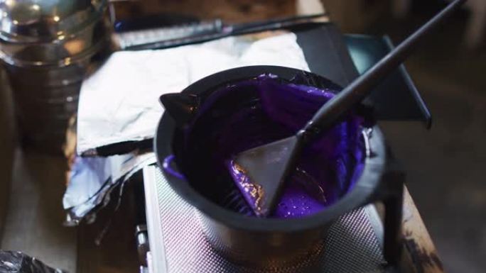 发廊桌上摆满紫色染发剂的黑碗