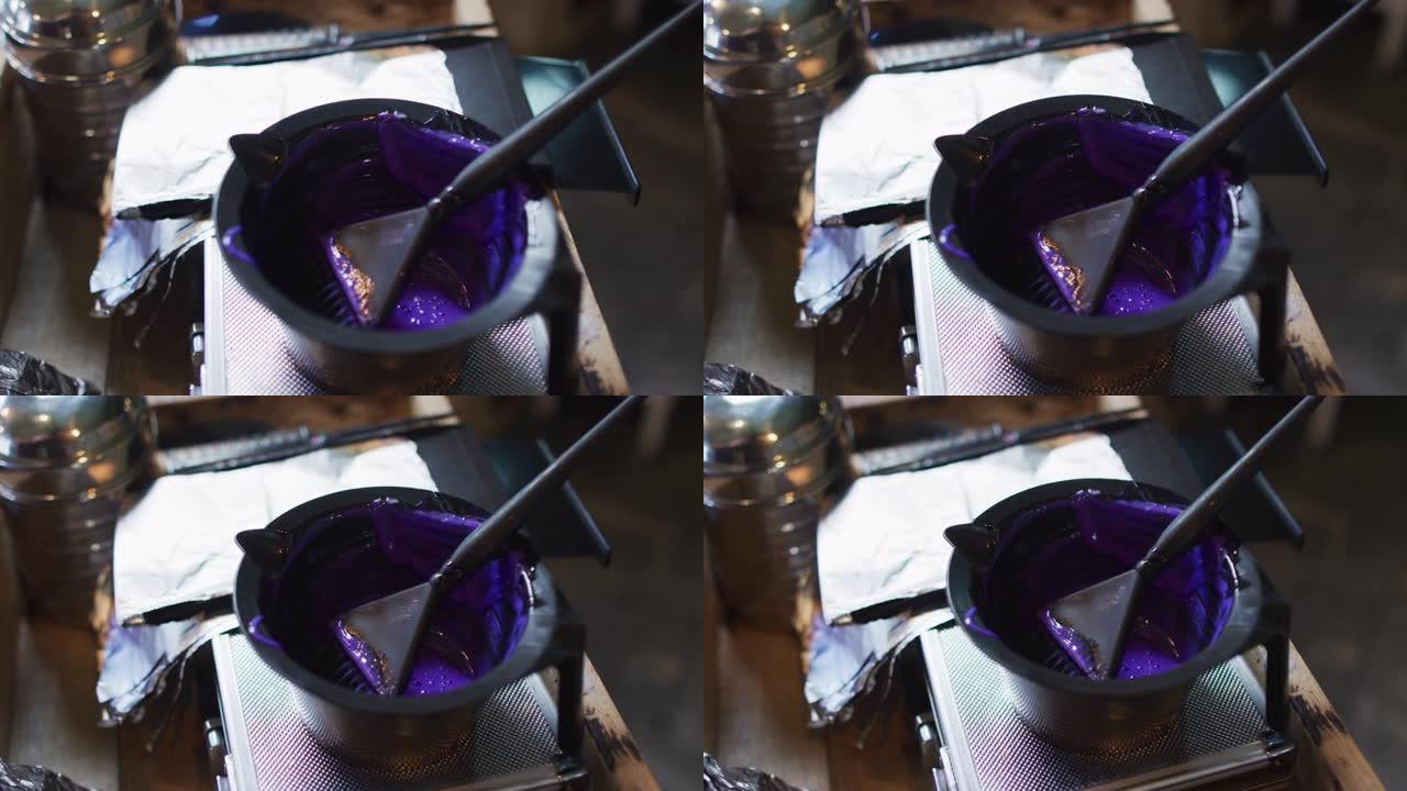 发廊桌上摆满紫色染发剂的黑碗