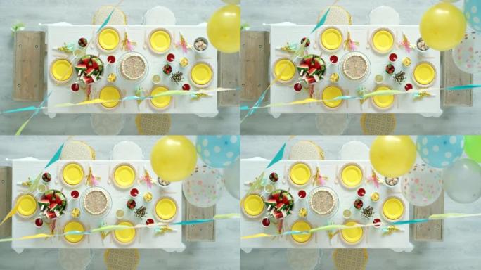 孩子们的生日聚会，装饰品和气球，上面放着蛋糕，小吃和甜食。装饰房间的俯视图，用于丰富多彩的儿童社交活