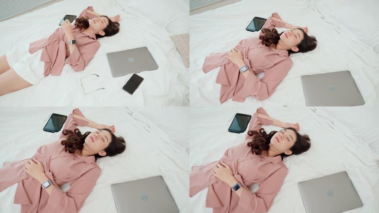 筋疲力尽的女人躺在床上睡着了，无线设备。