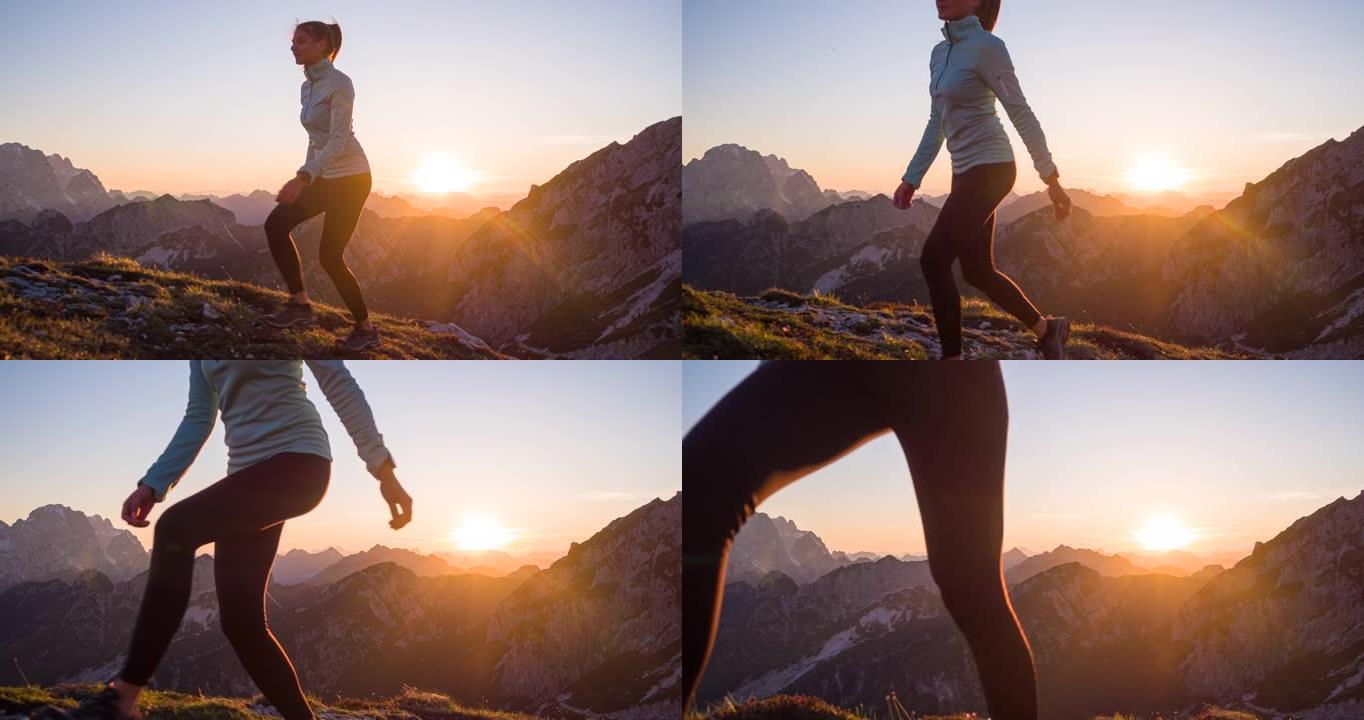 健康的女运动员保持健康的生活方式，日落时在岩石小径和草坡上徒步旅行