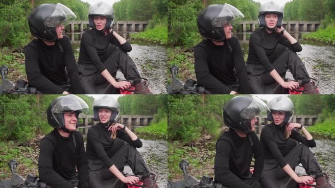 夫妇坐在河边的四轮摩托上聊天