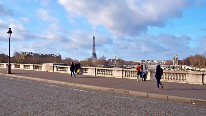 从巴黎的一座桥对面可以看到著名的埃菲尔铁塔。自行车手和行人