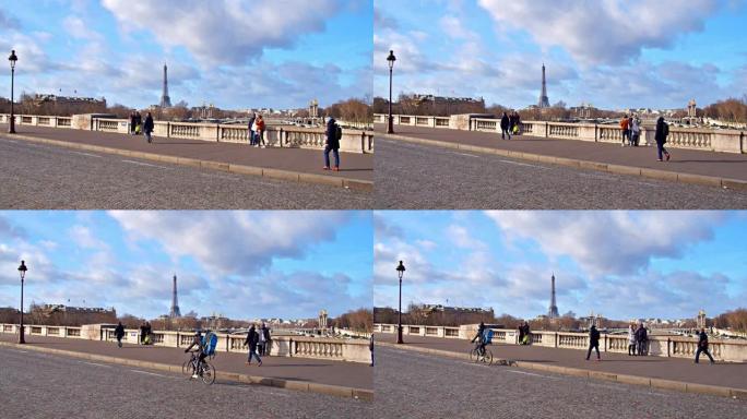从巴黎的一座桥对面可以看到著名的埃菲尔铁塔。自行车手和行人
