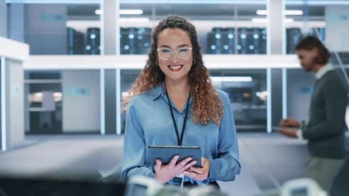 一位美丽的西班牙裔女性戴着眼镜，使用平板电脑，看着相机并微笑着的肖像。女商人，信息技术经理，机器人工