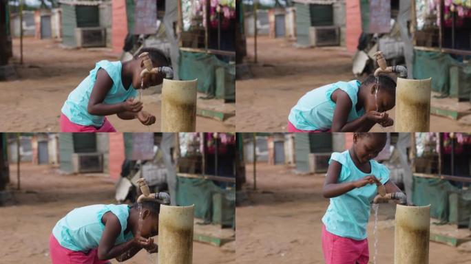 贫穷。不平等。贫穷的黑人非洲女孩在非正式定居点贫民窟的公共水龙头里喝水