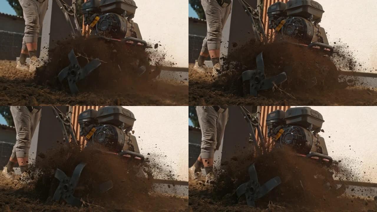 时间经纱SLO MO园丁使用前齿耕作机犁过坚硬的污垢和土壤