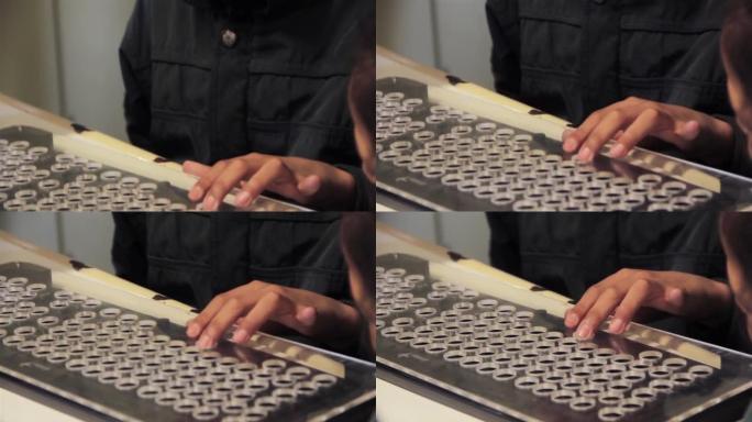 在课堂上的计算机课程中，一名视力障碍的男高中生的手触摸了计算机键盘。特写。