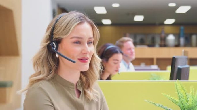 女商人戴着电话耳机与客户服务中心的呼叫者通话