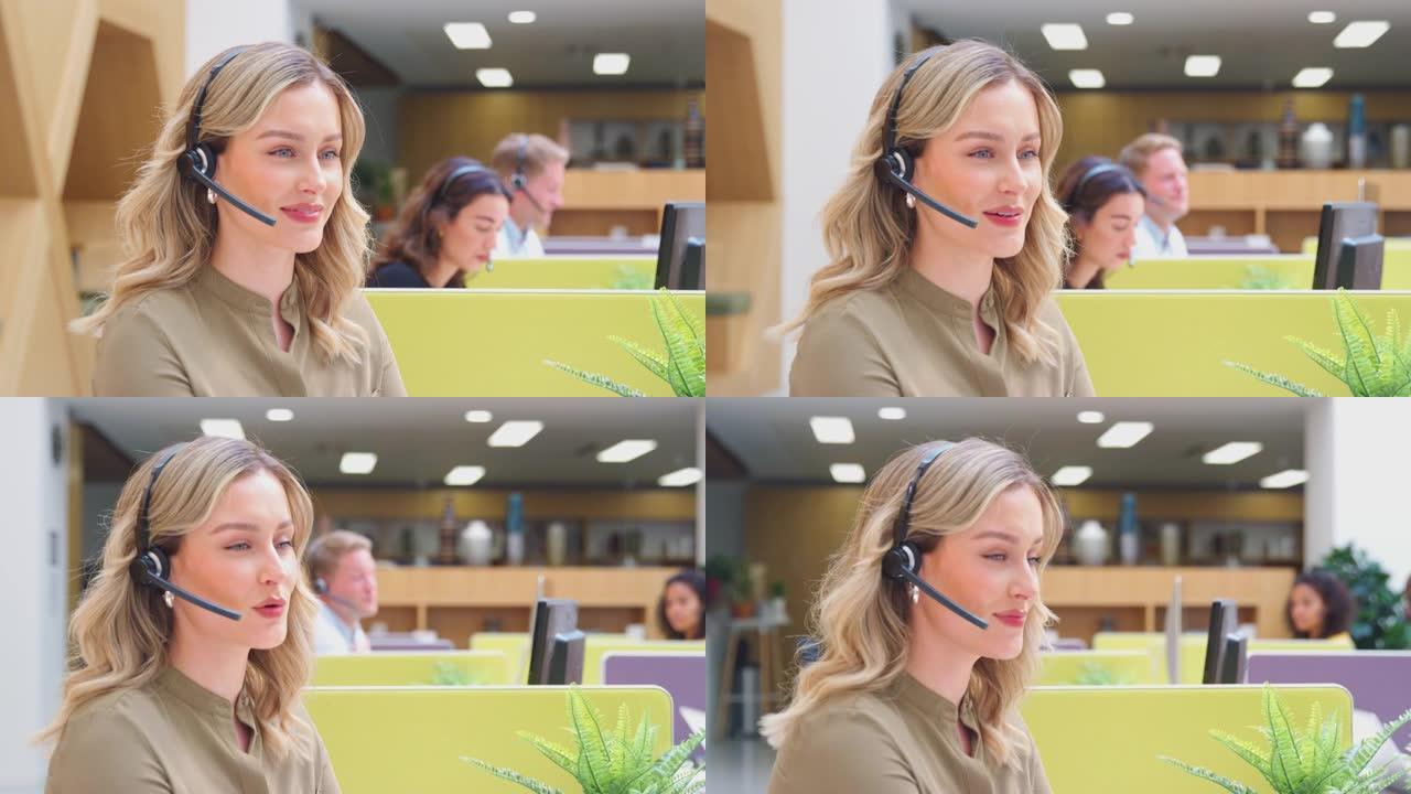 女商人戴着电话耳机与客户服务中心的呼叫者通话
