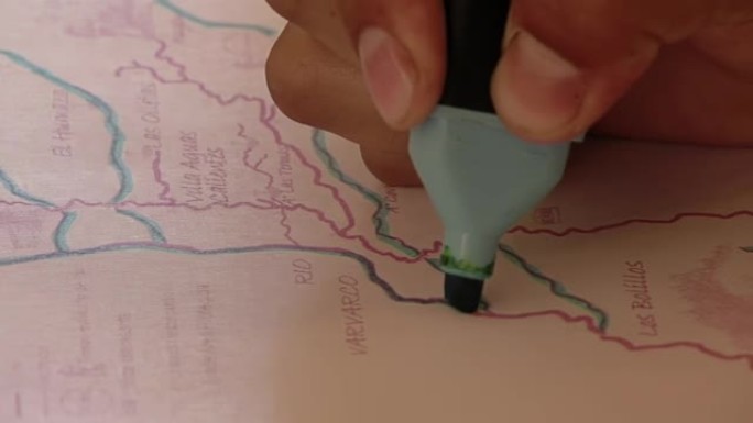阿根廷小学生用荧光笔在内乌肯省的地图上工作。特写。
