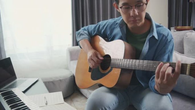 亚洲音乐家在家用笔记本电脑在社交媒体上直播写作歌曲
