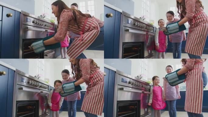 母女俩一起从家里厨房的烤箱里拿出新鲜出炉的纸杯蛋糕
