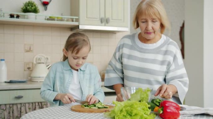 奶奶和孩子准备沙拉切蔬菜，在家聊天