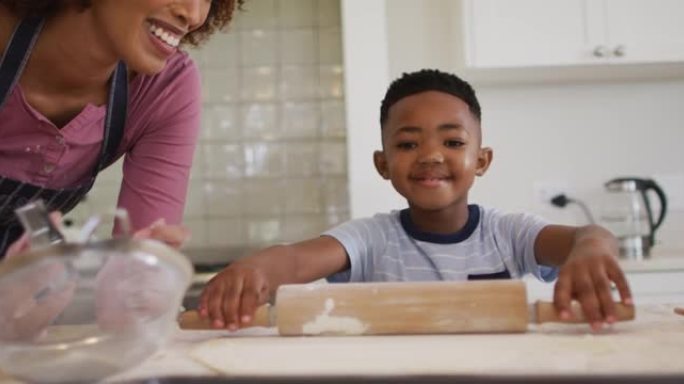 非裔美国母亲和儿子在家里的厨房里一起烘烤