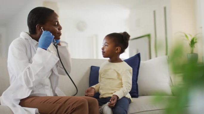 非裔美国女医生在家中与女孩患者交谈，使用听诊器并微笑