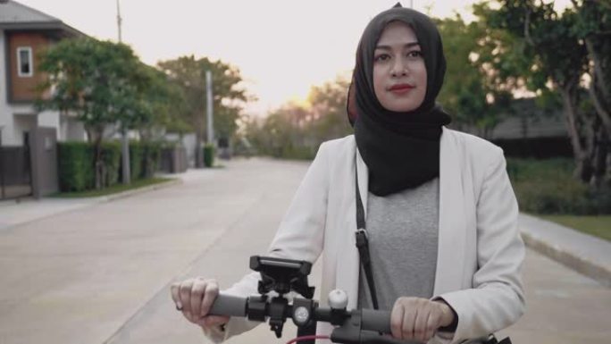 年轻的穆斯林妇女用电动滑板车在智能手机上搜索地图