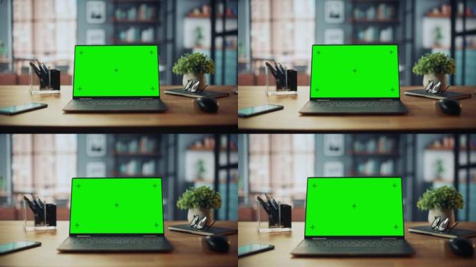笔记本电脑，带有模拟绿屏显示屏，站在舒适的客厅的桌子上。在背景中，时尚的现代明亮的家庭办公室工作室白