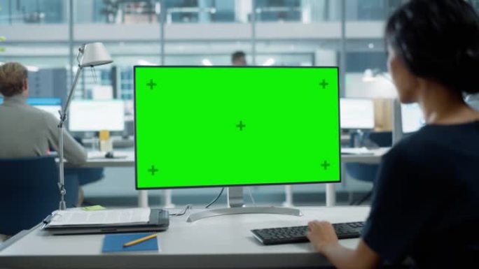 用色度键绿屏模拟显示在台式计算机上工作的女商人的肩膀特写镜头。数字项目经理使用键盘和鼠标键入数据。