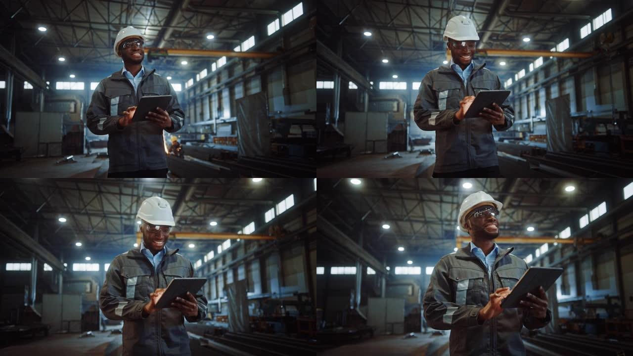 专业重工业工程师/穿着安全制服和安全帽的工人使用平板电脑。微笑的非洲裔美国工业专家走在金属建筑制造商